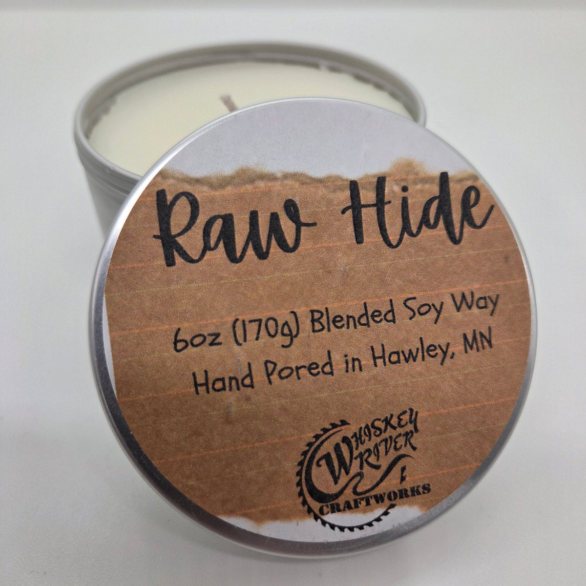Handcrafted "Raw Hide" 6oz soy-blend candle, featuring a bold, premium leather scent that captures the authentic aroma of a traditional workshop.
