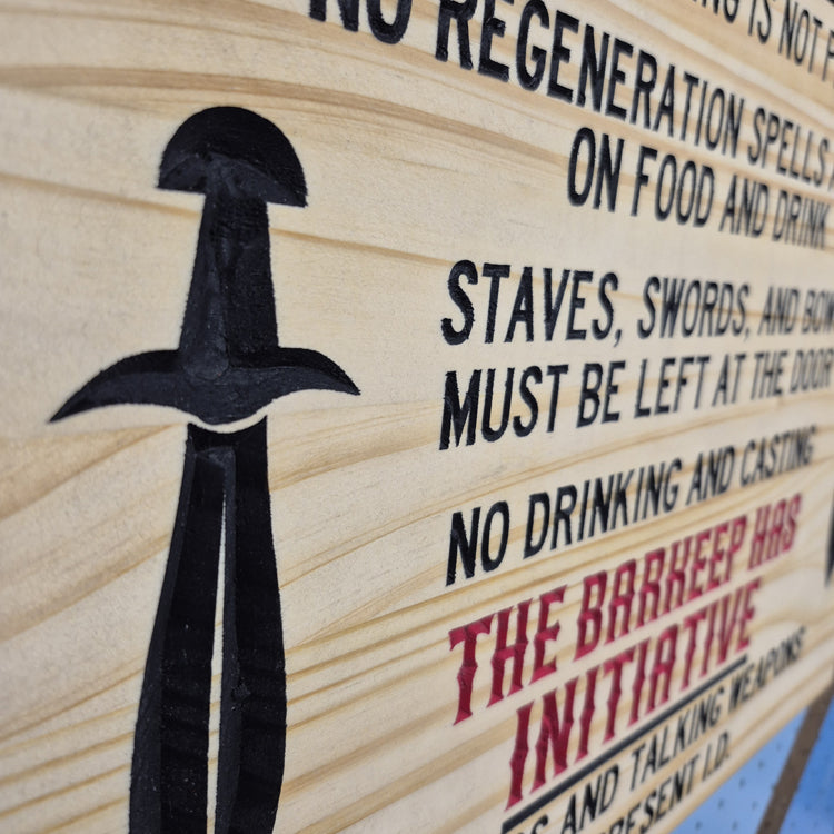 A tight close-up shot focusing on one of the carved swords and the detailed rules text, showcasing the incredibly crisp CNC machining and the precise hand-painted black details filling the background cuts.