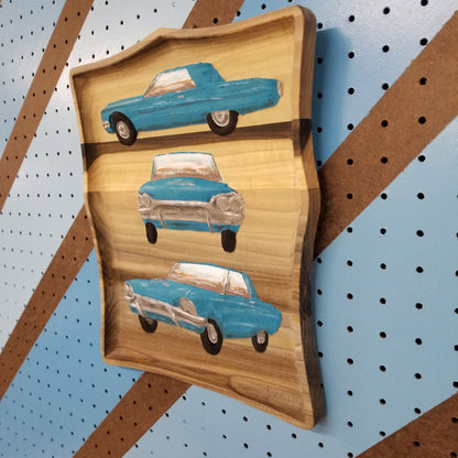 Side view showing the dimensional carving depth and hand-painted finish of a custom hardwood car sign.