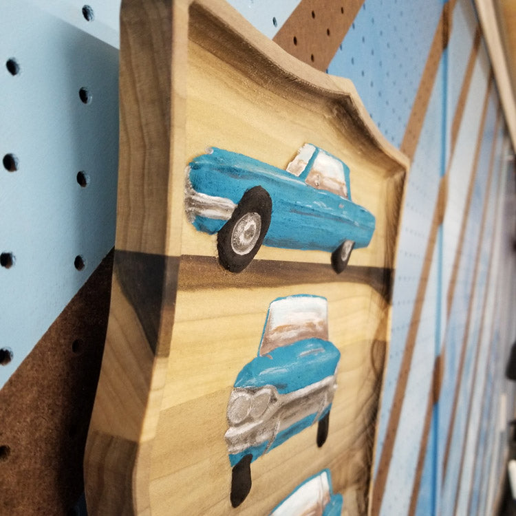 Close-up of the detailed multi-view automotive carving on a premium solid hardwood plaque.