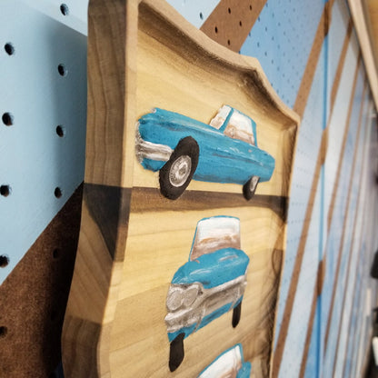 Close-up of the detailed multi-view automotive carving on a premium solid hardwood plaque.
