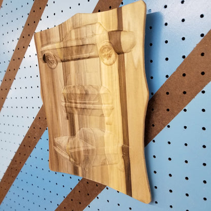 Side profile of a raw, unpainted multi-view car carving on solid hardwood, highlighting the dimensional depth.