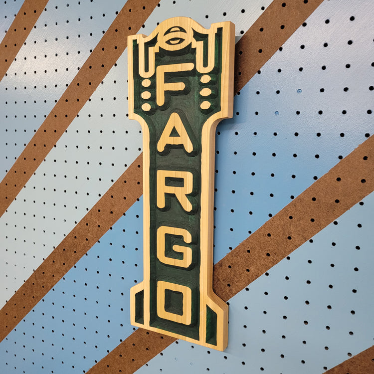 Angled shot of a Relief carved hardwood sign featuring the iconic Fargo Theatre marquee design.