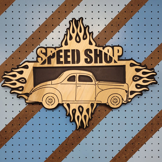 Custom hardwood Speed Shop garage sign with relief carved vintage hot rod and flame design on a striped pegboard.