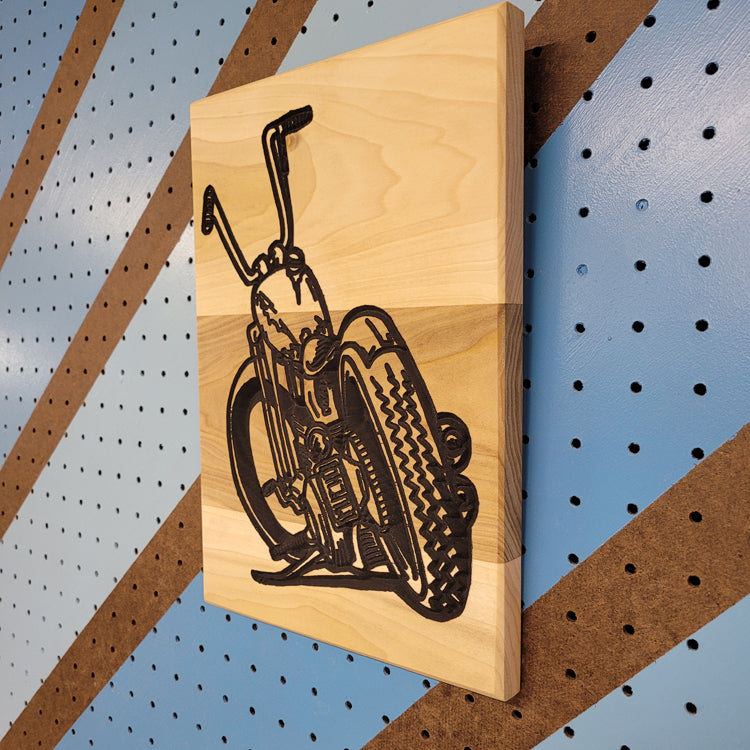 Angled shot of a relief carved hardwood sign featuring a detailed chopper motorcycle resting on its kickstand.