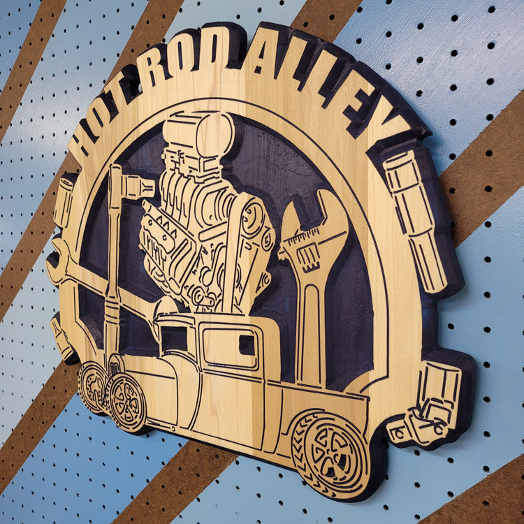 Angled shot of a fully customizable relief carved hardwood round sign featuring a vintage hot rod truck, blower engine, and wrenches.