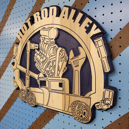 Angled shot of a fully customizable relief carved hardwood round sign featuring a vintage hot rod truck, blower engine, and wrenches.