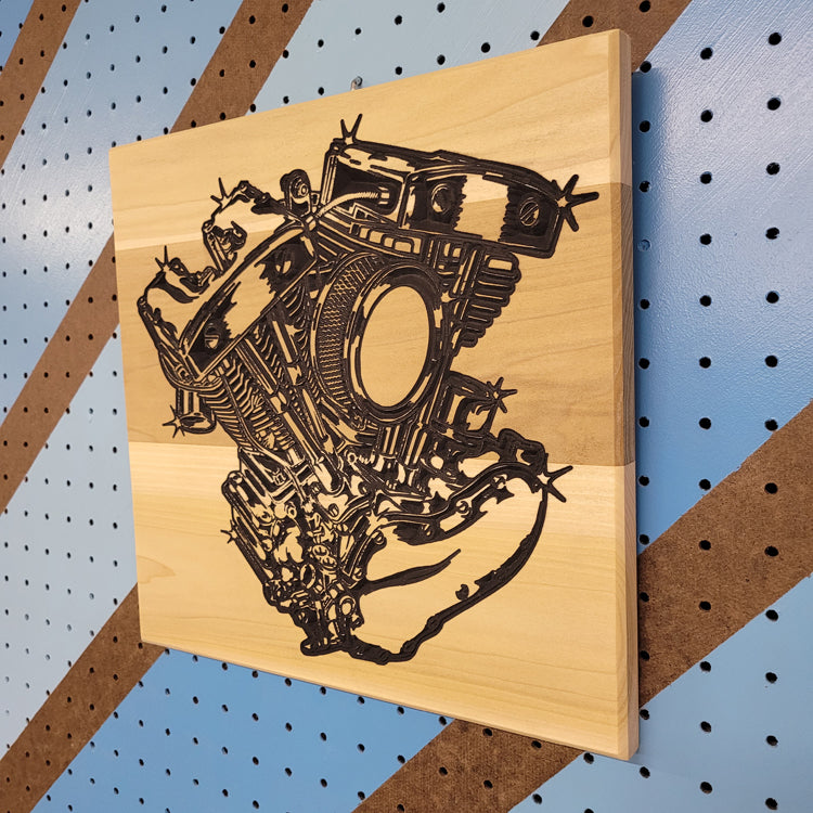 Angled shot of a custom hardwood V-Twin engine motorcycle sign with carved shop art relief design on a blue pegboard.