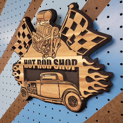 High-angle shot of a relief carved hardwood sign with a 1932 Ford hot rod, black blower engine, checkered flags, and Hot Rod Shop text.