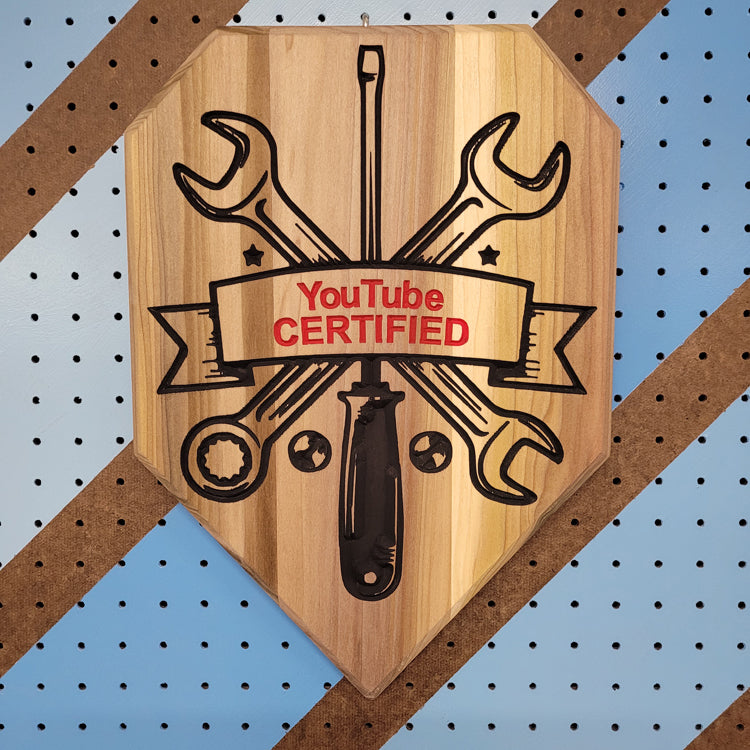 Custom hardwood wrench driver garage sign with YouTube Certified relief carving on a workshop pegboard