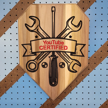 Custom hardwood wrench driver garage sign with YouTube Certified relief carving on a workshop pegboard