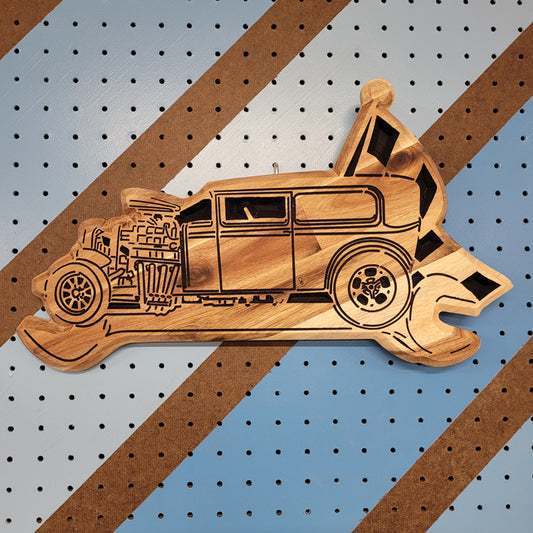 Custom hardwood wrench flag garage sign with detailed hot rod relief carving on a workshop pegboard.