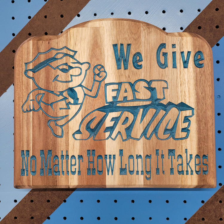 Relief carved hardwood sign featuring a cartoon mechanic and text: We Give Fast Service No Matter How Long It Takes.