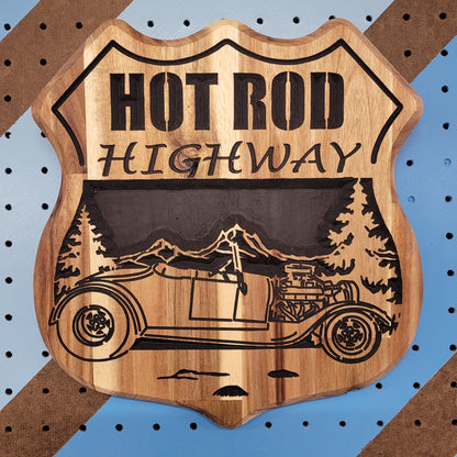 Fully customizable relief carved hardwood shield-shaped sign featuring a vintage hot rod convertible, pine trees, and Hot Rod Highway text.