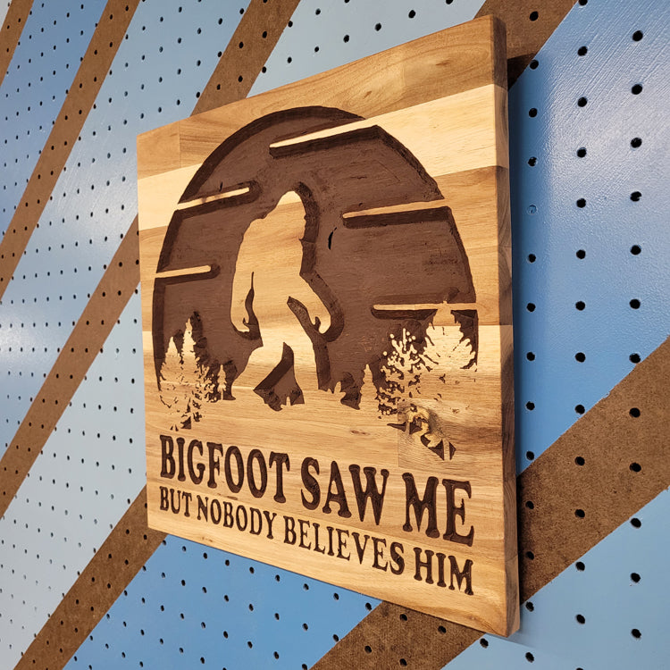 Angled shot of a Handcrafted relief-carved hardwood sign featuring a Bigfoot silhouette and the text "BIGFOOT SAW ME BUT NOBODY BELIEVES HIM."