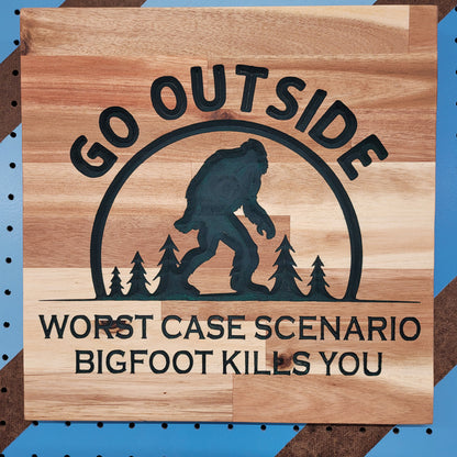 Handcrafted relief-carved hardwood sign featuring a Bigfoot silhouette and the text "Go Outside, Worst Case Scenario Bigfoot Kills You."