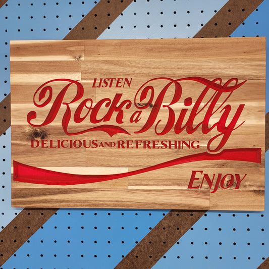 Relief carved hardwood sign with a classic red soda parody design and Rock-a-Billy text on a striped pegboard.