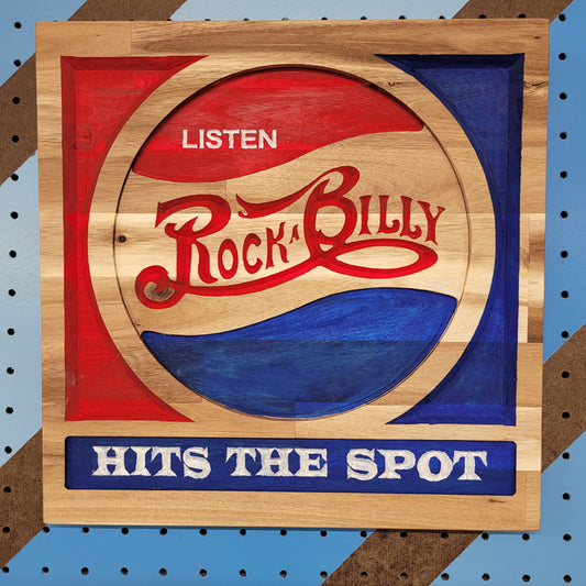 Relief carved hardwood sign with red and blue retro soda parody design, Listen Rockabilly Hits the Spot text on pegboard.