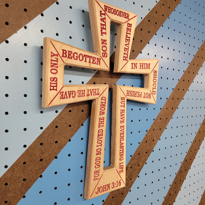 Angled shot of a Handcrafted relief-carved hardwood cross, featuring the text of John 3:16.