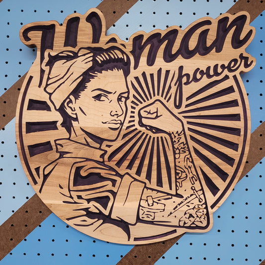 Custom hardwood Woman Power garage sign with updated Rosie the Riveter relief carving on a blue pegboard