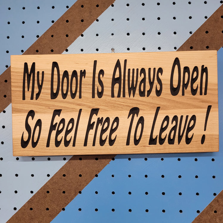 Relief carved hardwood sign featuring the text: My Door Is Always Open So Feel Free To Leave!