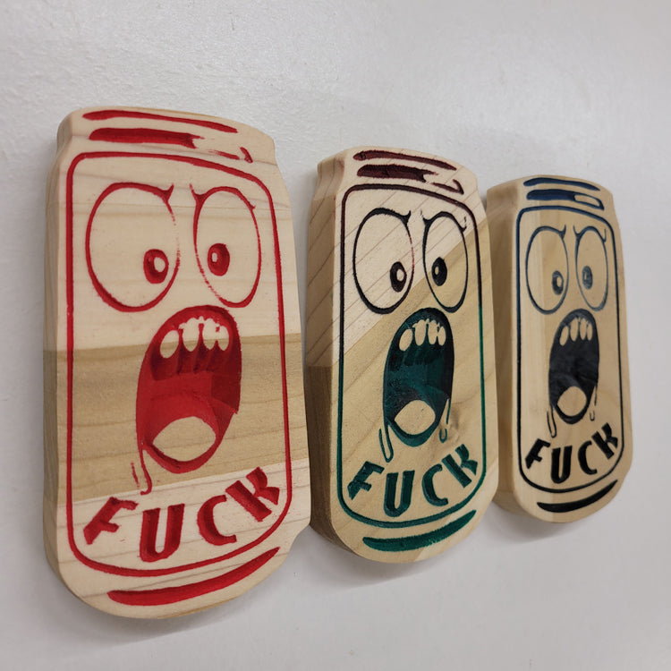 Angled shot of three relief carved hardwood can-shaped signs with screaming cartoon faces and the text FUCK.