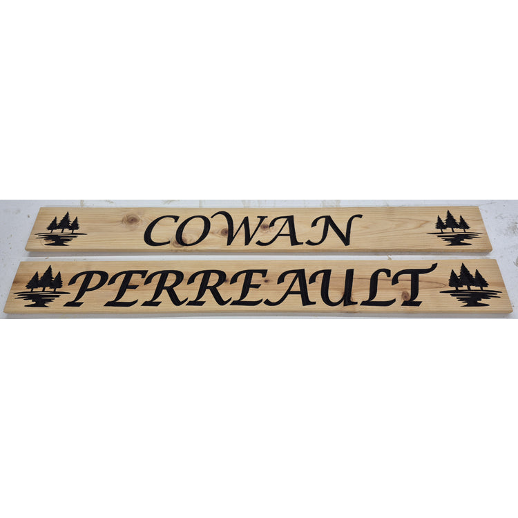 Custom CNC-carved wooden nameplates featuring 'Cowan' and 'Perreault' text with pine tree silhouettes, handcrafted and finished by Whiskey River Craftworks.
