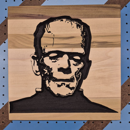Relief carved hardwood sign featuring a detailed Frankenstein monster portrait.