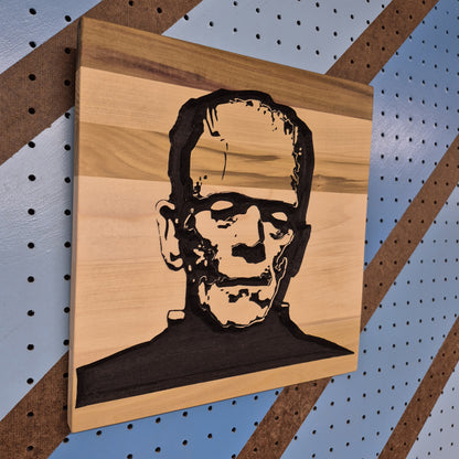 Angled shot of a Relief carved hardwood sign featuring a detailed Frankenstein monster portrait.