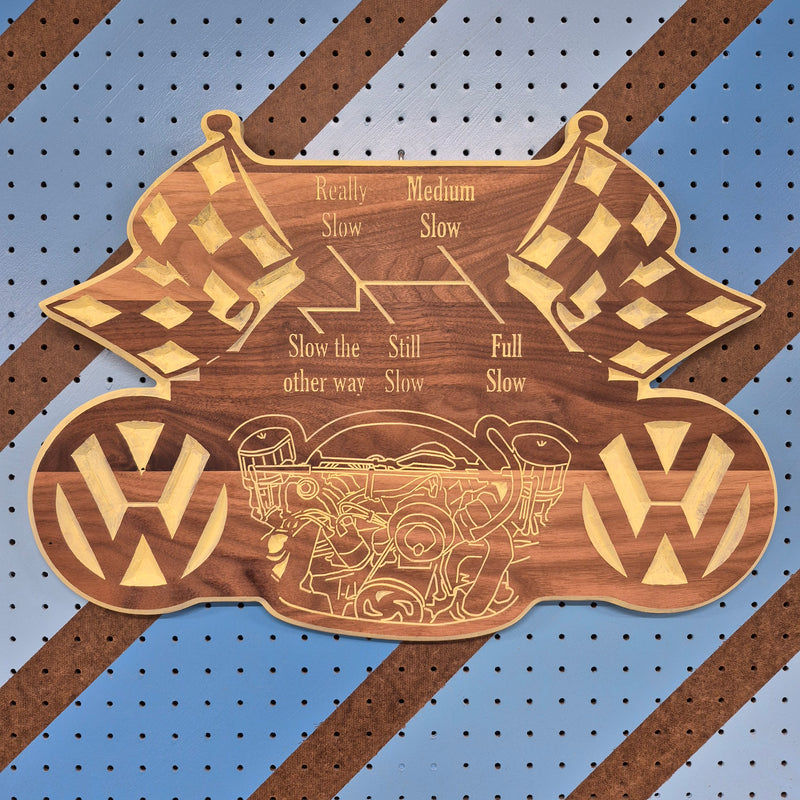 Custom CNC-engraved wooden decorative plaque featuring a vehicle emblem, checkered racing flags, and mechanical speed setting text on a blue pegboard background
