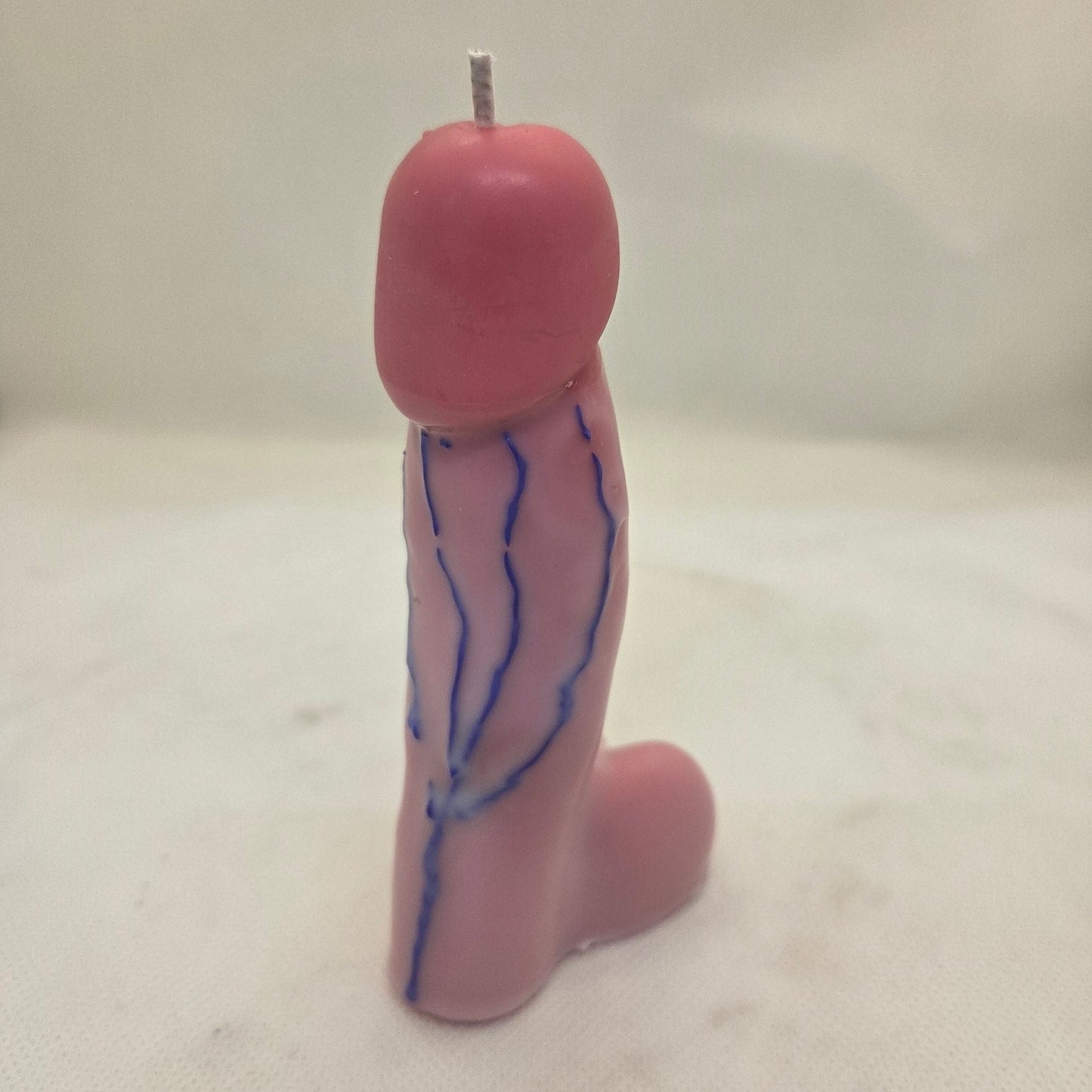 Handcrafted manhood-shaped novelty candle with a lifelike finish on a white background.