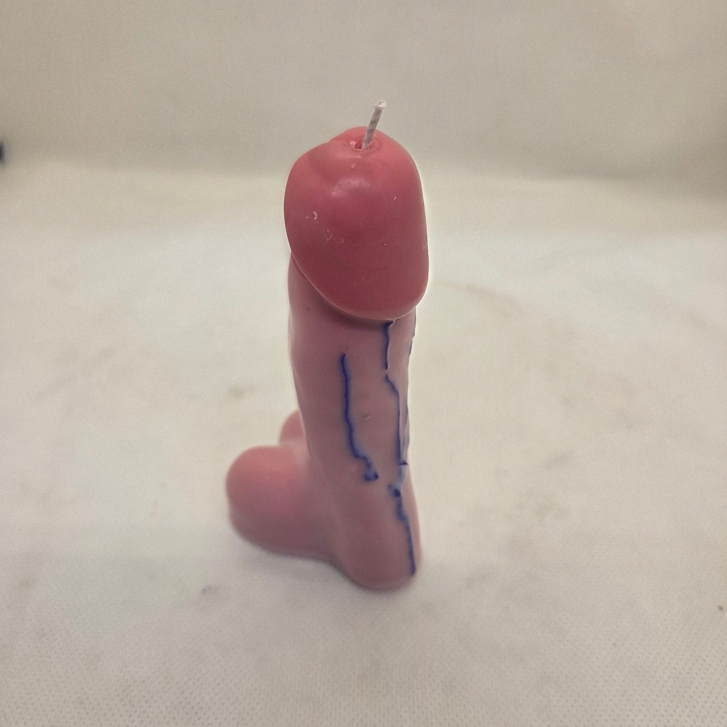 Handcrafted manhood-shaped novelty candle with a lifelike finish on a white background.