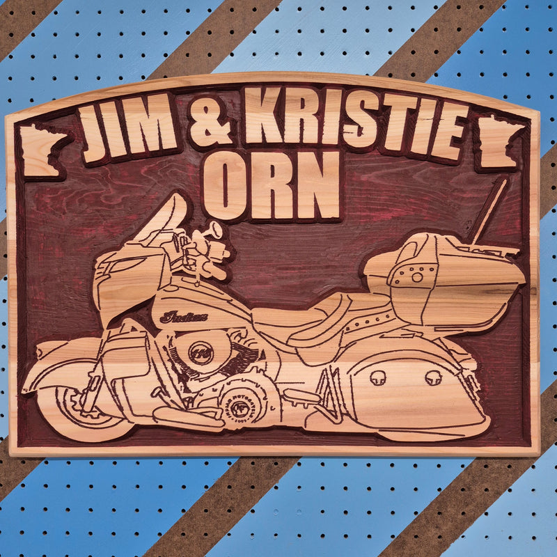 Custom CNC-carved wooden plaque featuring a touring motorcycle silhouette, the text 'Jim & Kristie Orn', and a small map outline of Minnesota.