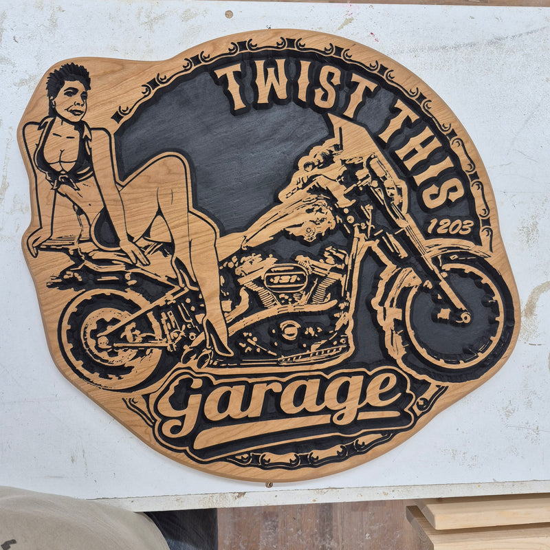 Custom CNC-carved wooden sign for 'Twist This Garage', featuring a portrait of a woman sitting on a motorcycle, handcrafted and finished by Whiskey River Craftworks.