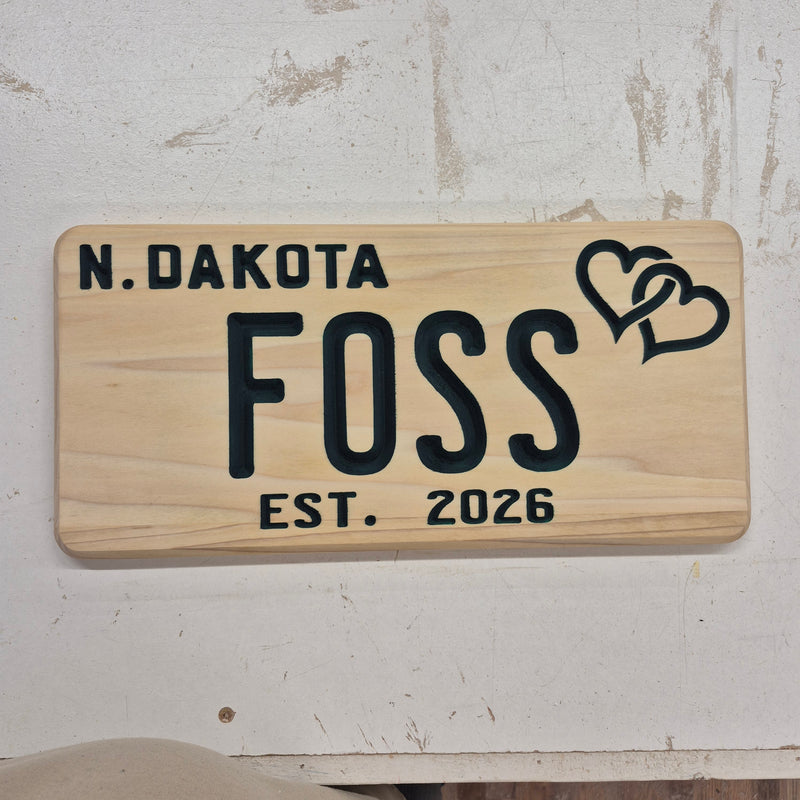 Custom CNC-carved wooden sign featuring the text 'N. Dakota', 'FOSS', 'EST. 2026', and an interlocking double heart design.