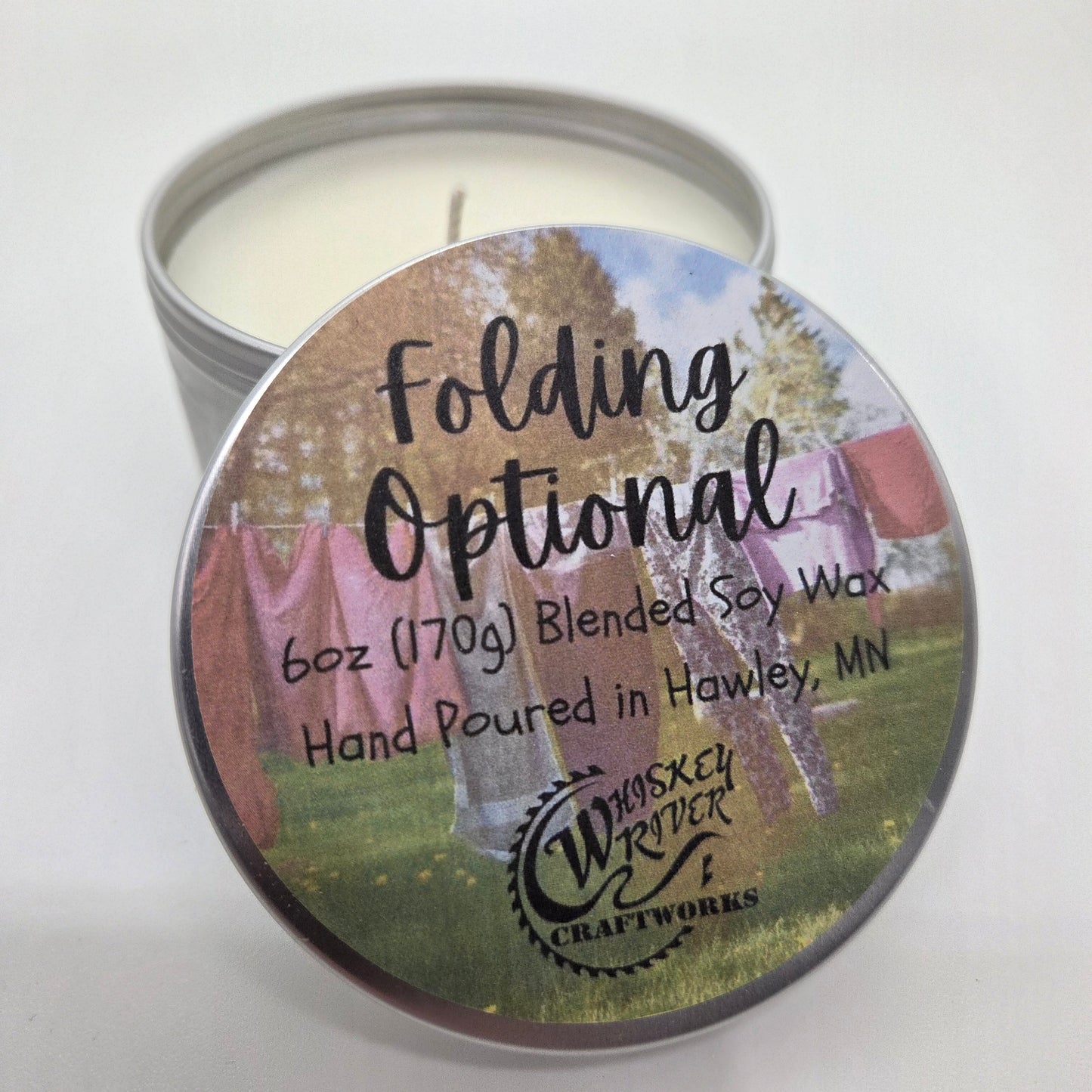 Handcrafted "Folding Optional" 6oz soy-blend candle, featuring a crisp and clean fresh linen scent, designed to evoke the comforting aroma of freshly washed laundry.