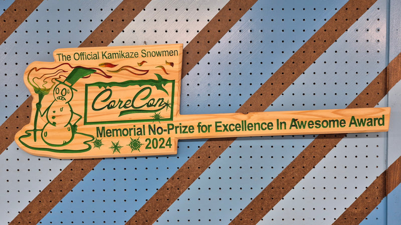 Custom CNC-engraved wooden plaque titled 'The Official Kamikaze Snowmen' and 'Memorial No-Prize for Excellence in Awesome Award 2024,' featuring a cartoon snowman character and decorative snowflake accents.