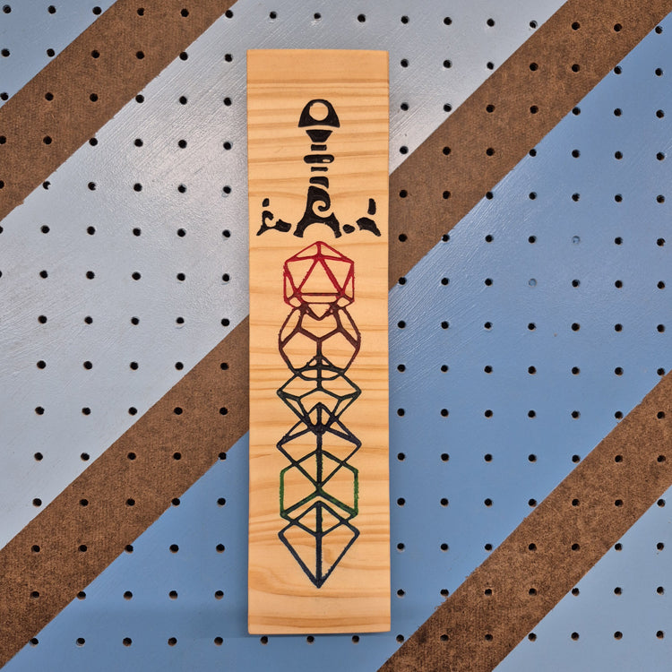 A vertical solid hardwood carved sign featuring the "Dice Sword" design. The carving depicts a detailed fantasy longsword with polyhedral RPG dice (d20, d12, d10, d8, d6, d4) embedded down the center of the blade and crossguard.