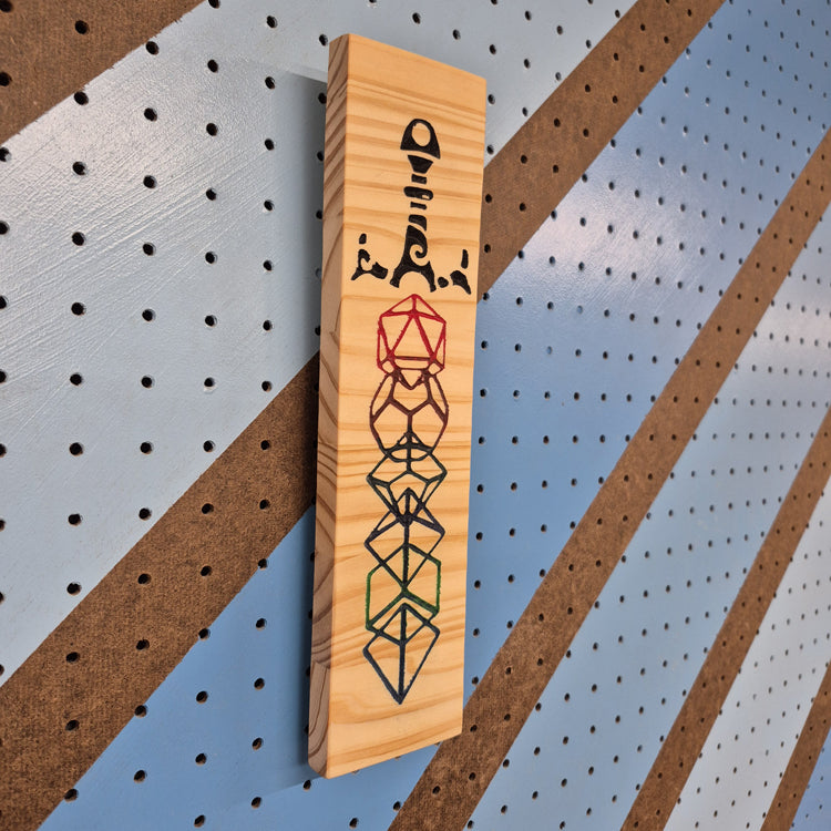 An angled, full-length shot of the custom carved Dice Sword wooden plaque, showcasing the dimensional depth of the CNC-machined cuts and the rich, natural patterns of the hardwood grain.