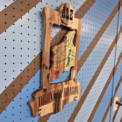 An angled side shot of the custom carved Drunken Dragon wooden plaque, highlighting the clean depth of the CNC relief cuts and the rich patterns of the natural hardwood grain.