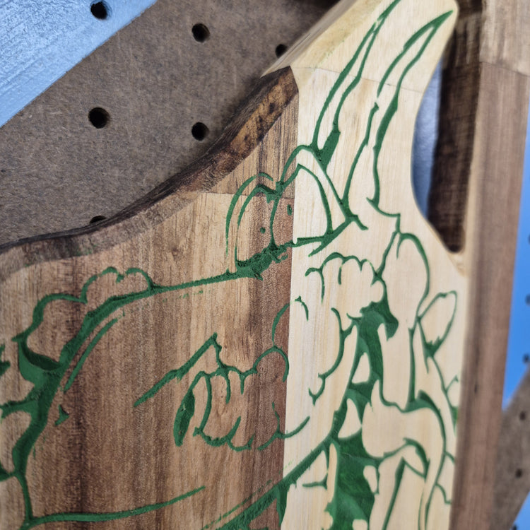 A tight close-up shot focusing on the top portion of the carving, highlighting the detailed text reading "The Drunken Dragon Pub" and the intricate textures carved into the dragon's face and wings.