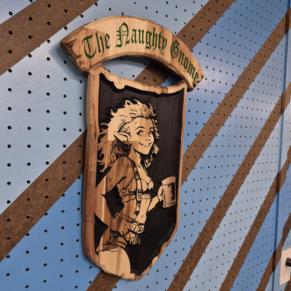 An angled side shot of the custom carved Naughty Gnome wooden plaque, showcasing the clean depth of the CNC relief cuts against a blue and brown striped pegboard wall
