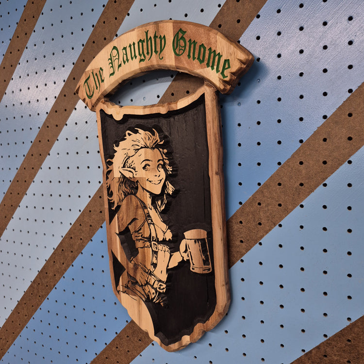A perspective view from the opposite angle of the gnome tavern sign, highlighting the crisp engraving and professional satin finish against a diagonal blue and brown striped pegboard.