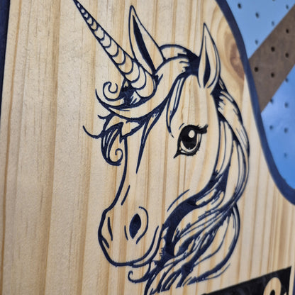 A tight close-up shot focusing on the unicorn's face and horn, showcasing the incredibly crisp CNC carving lines, the rich natural wood grain textures, and the precise hand-painted black and blue details filling the background cuts.