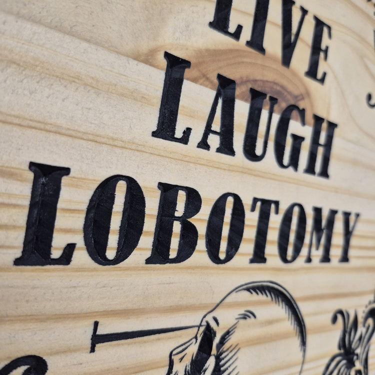 A tight close-up shot focusing on the lower section of the plaque, highlighting the precise CNC carving lines of the skull and the crisp hand-painted black details filling the background cuts.