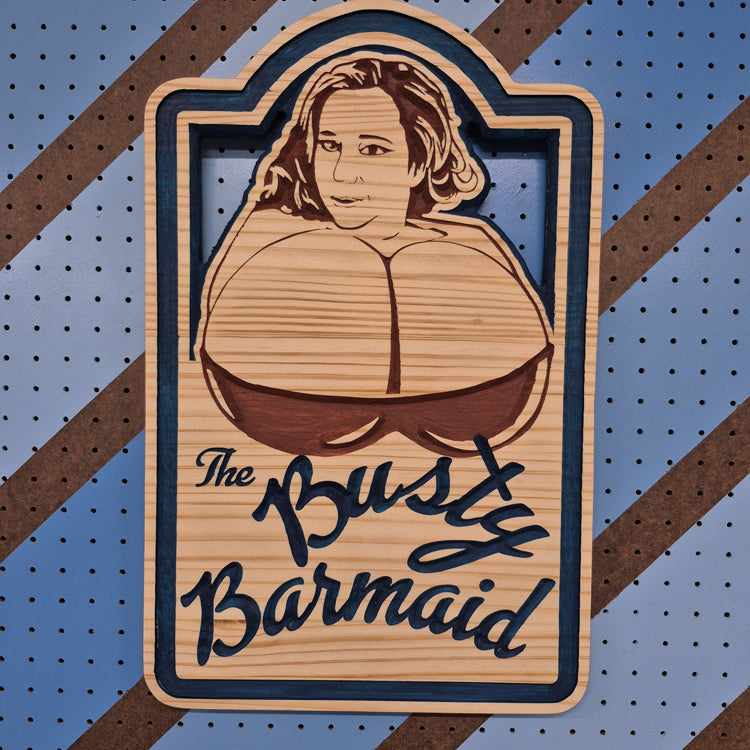 A vertical solid hardwood carved sign featuring a cheerful fantasy tavern maid gesturing to her large bosom. The carving features crisp hand-painted accents against a blue and brown striped pegboard.