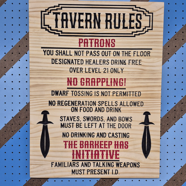 A vertical solid hardwood carved tavern sign featuring funny fantasy rules flanked by two swords. The detailed CNC text features crisp hand-painted black accents against a blue and brown striped pegboard.