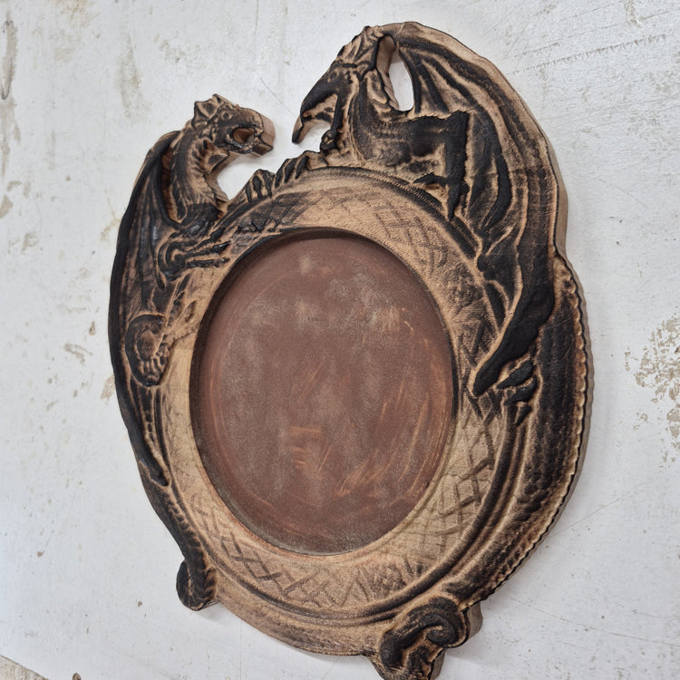 An angled side shot of the circular Dragon Pair wooden dice tray, highlighting the impressive dimensional depth of the 3D CNC carving and the texture of the flocked center.