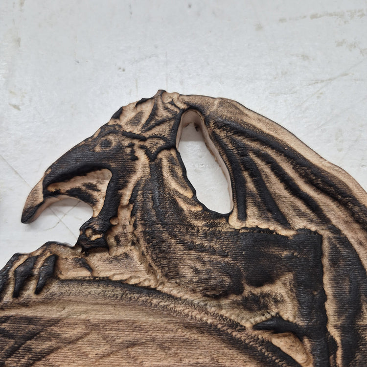 A tight close-up shot focusing on the left dragon's head and wing, highlighting the incredibly crisp CNC carving lines, the natural wood grain, and the precise accents.