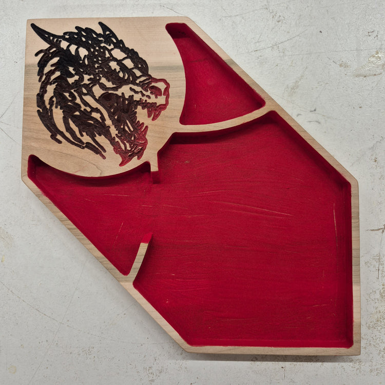 A top-down view of an asymmetrical solid hardwood dice rolling tray featuring a detailed dragon head carved in the corner, accented with vibrant multi-color hand-painting, and a red flocked velvet center.